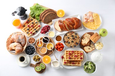 Photo of Different meals served for breakfast on white table, flat lay