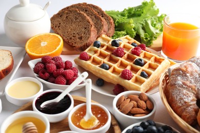 Photo of Different meals served for breakfast on white table, closeup. Buffet menu