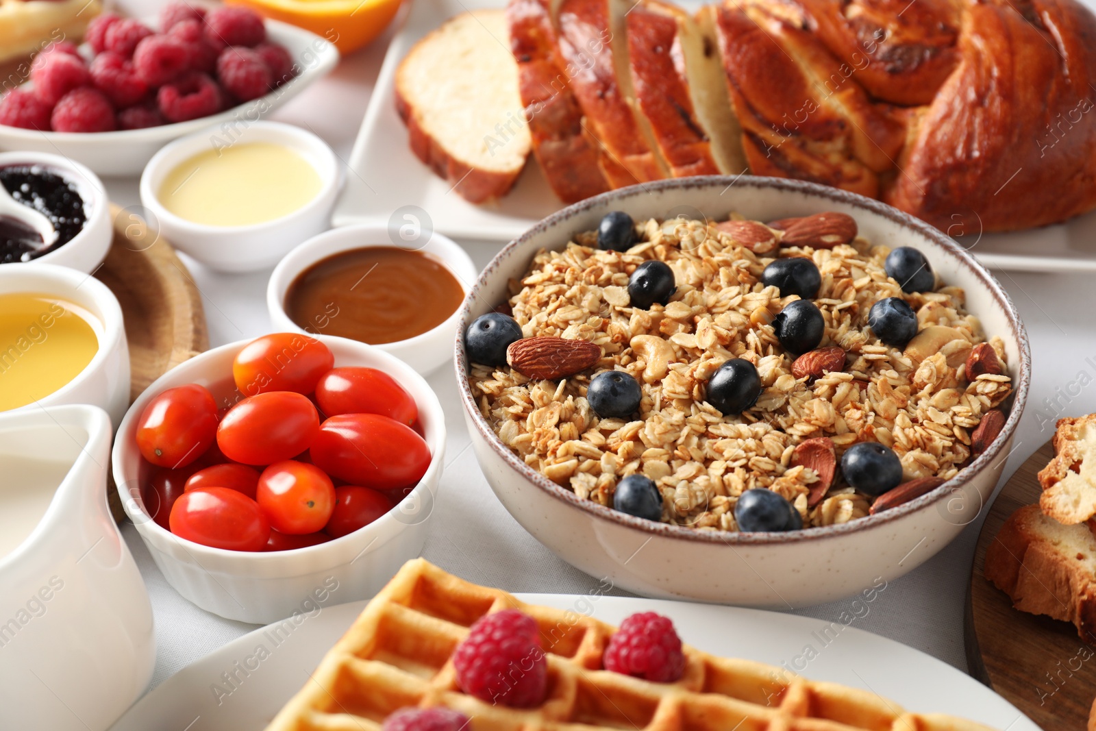 Photo of Different meals served for breakfast on white table, closeup. Buffet menu