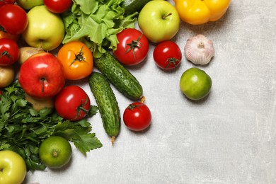 Healthy vegetarian food. Different vegetables and apples on grey textured table, flat lay. Space for text