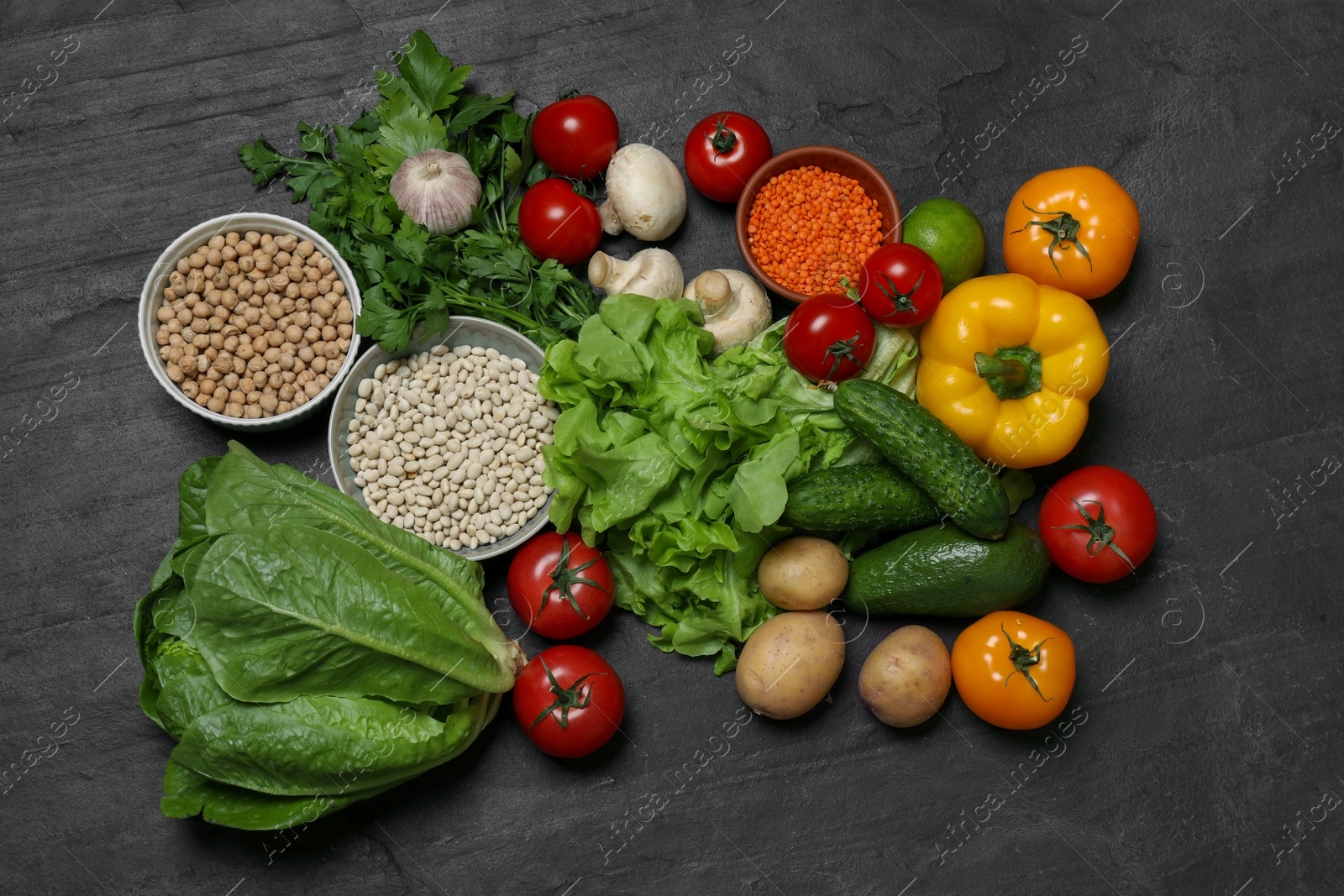 Photo of Healthy vegetarian food. Different vegetables, mushrooms and lentils on dark textured table, flat lay