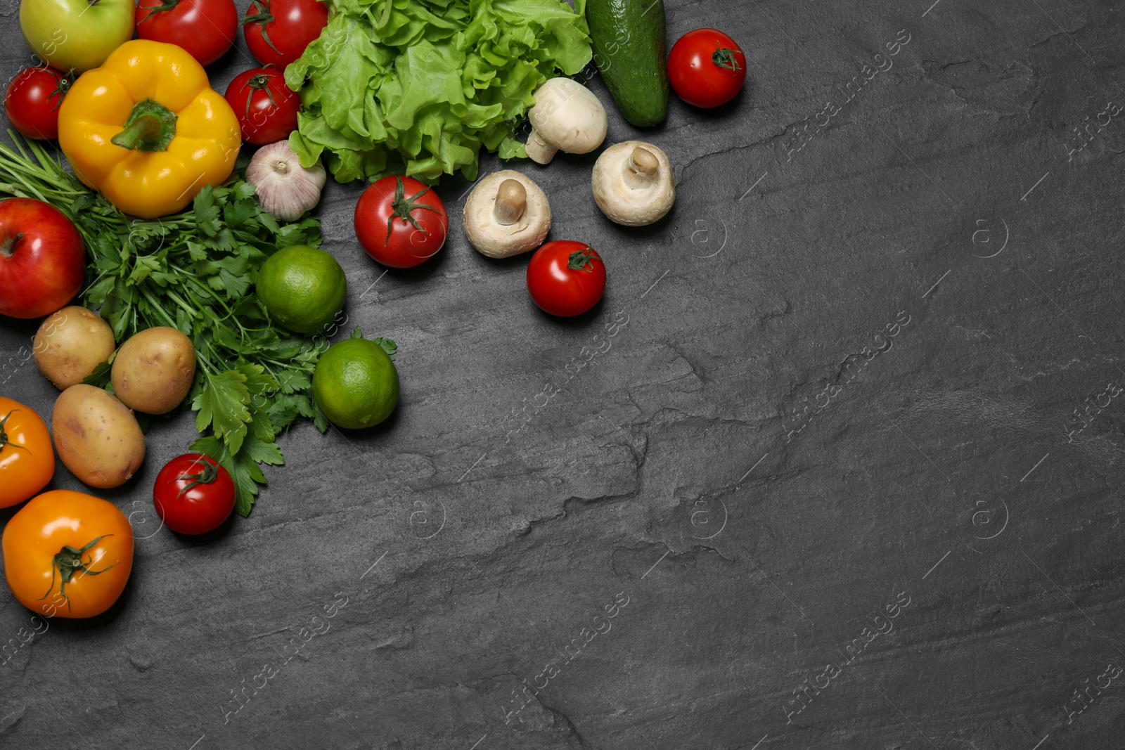 Photo of Healthy vegetarian food. Different vegetables, mushrooms and lime on dark textured table, flat lay. Space for text