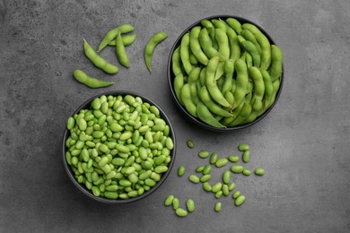 Photo of Raw green edamame soybeans and pods on grey table, top view