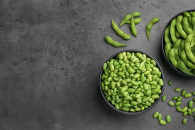 Photo of Raw green edamame soybeans and pods on grey table, top view