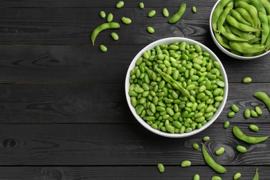 Photo of Raw green edamame soybeans and pods on wooden table, flat lay. Space for text