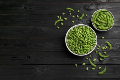 Photo of Raw green edamame soybeans and pods on wooden table, flat lay. Space for text