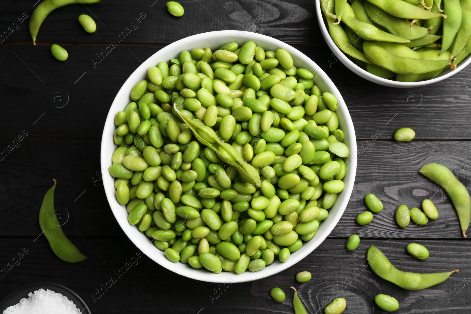 Photo of Raw green edamame soybeans and pods on wooden table, flat lay