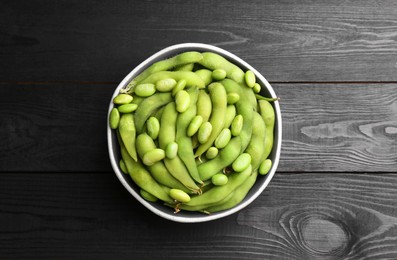 Photo of Raw green edamame soybeans and pods on wooden table, top view