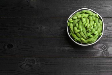 Photo of Raw green edamame soybeans and pods on wooden table, top view. Space for text