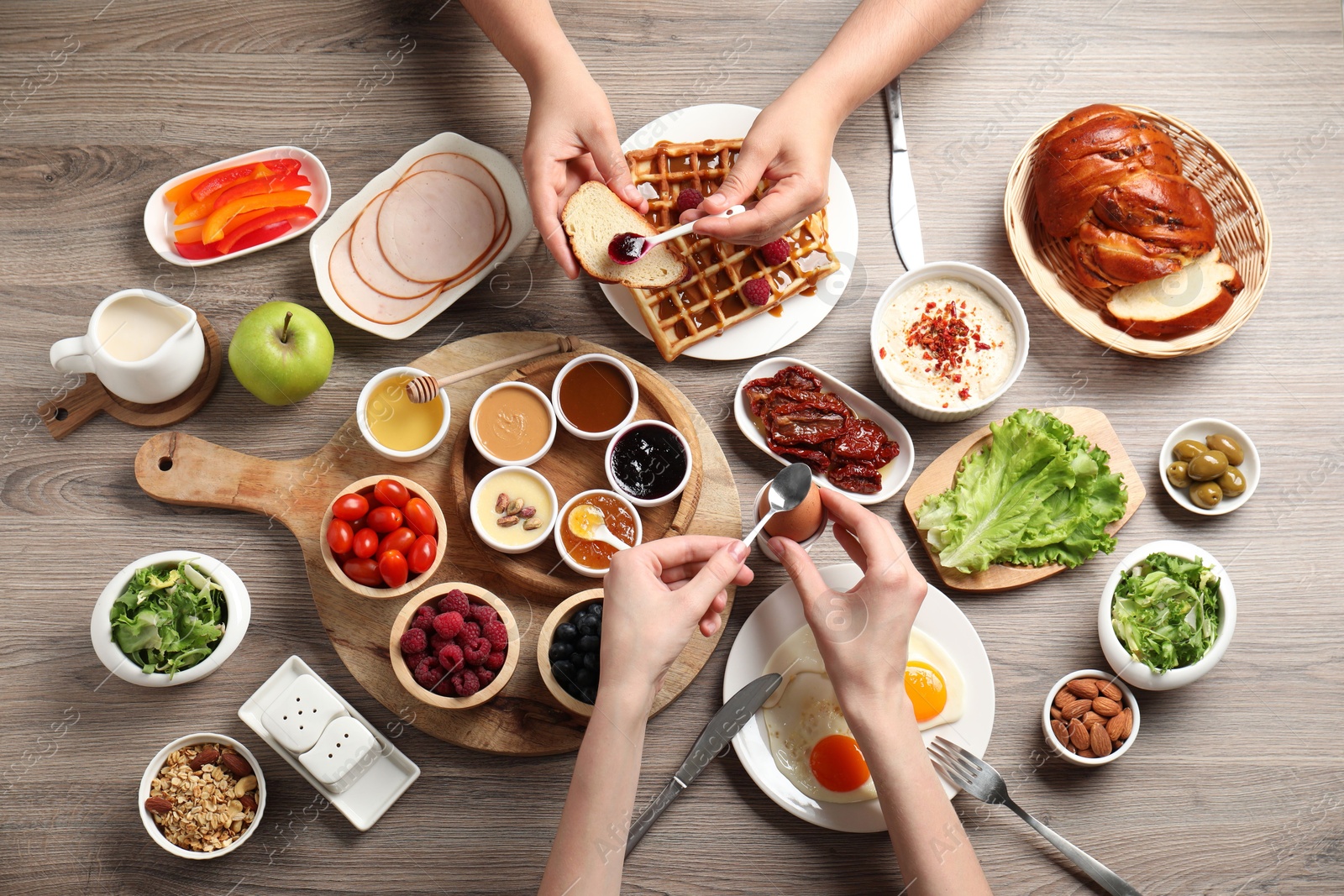 Photo of People having breakfast at wooden table, top view