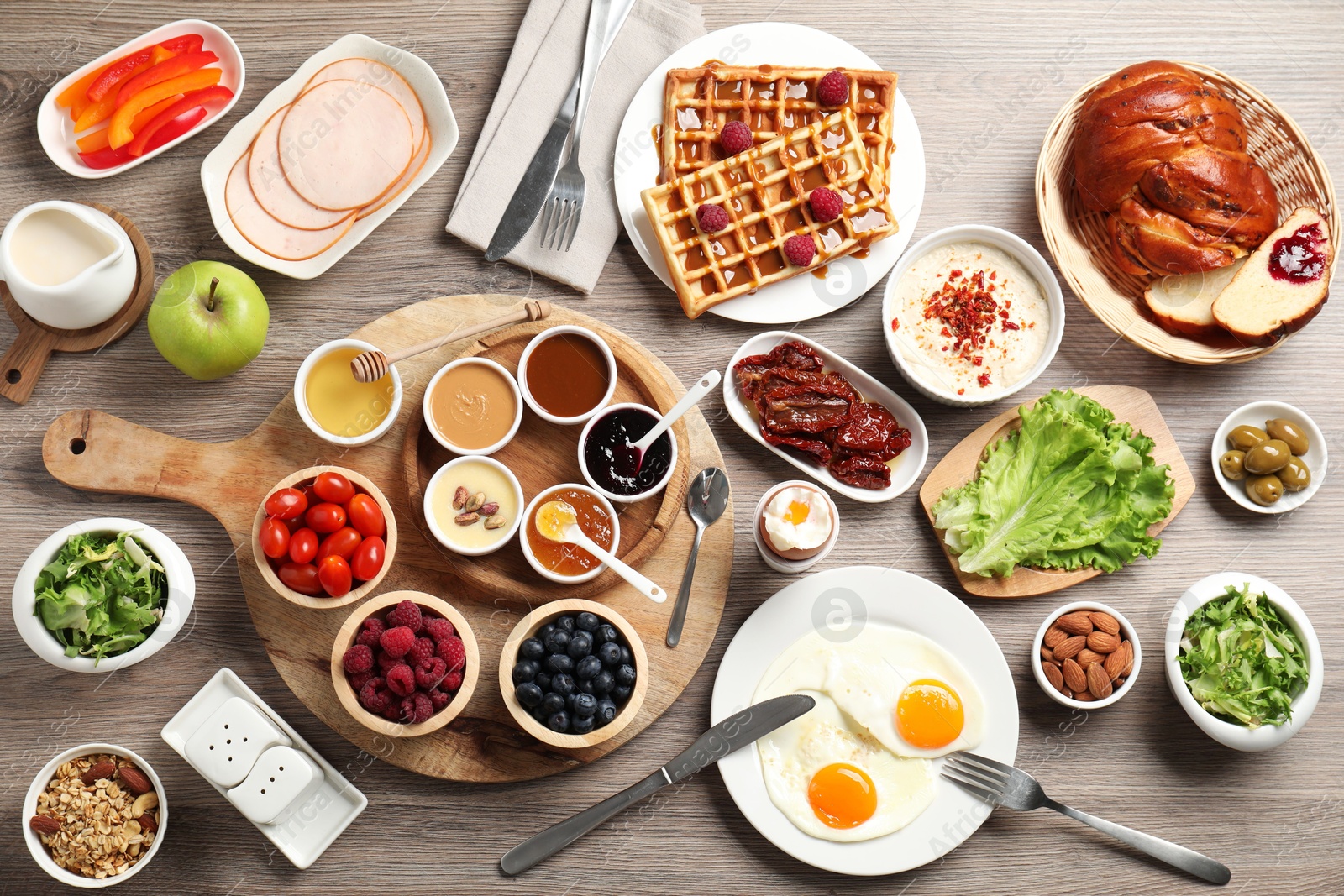 Photo of Different meals served for breakfast on wooden table, flat lay