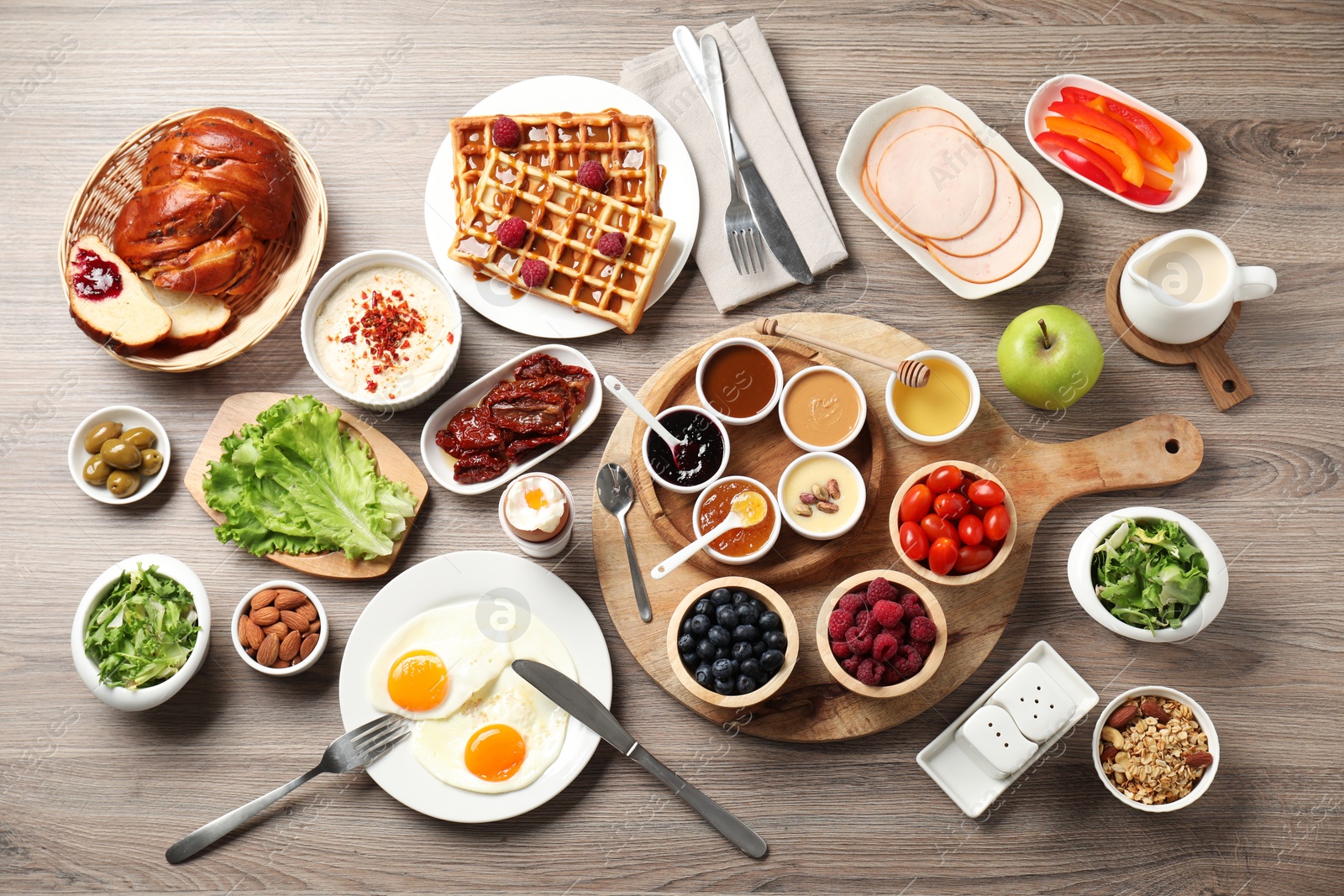 Photo of Different meals served for breakfast on wooden table, flat lay