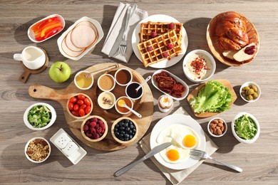 Different meals served for breakfast on wooden table, flat lay