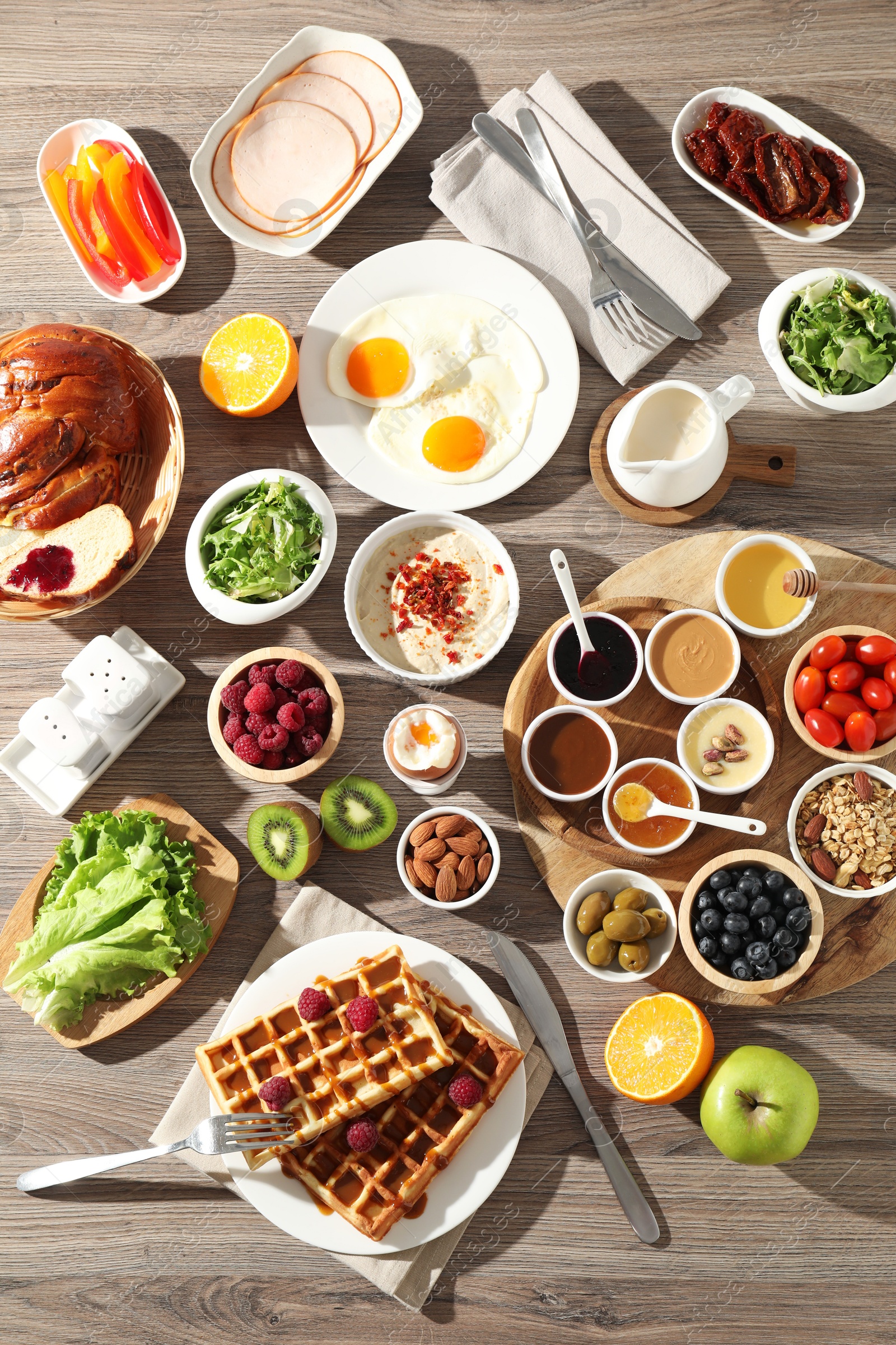 Photo of Different meals served for breakfast on wooden table, flat lay