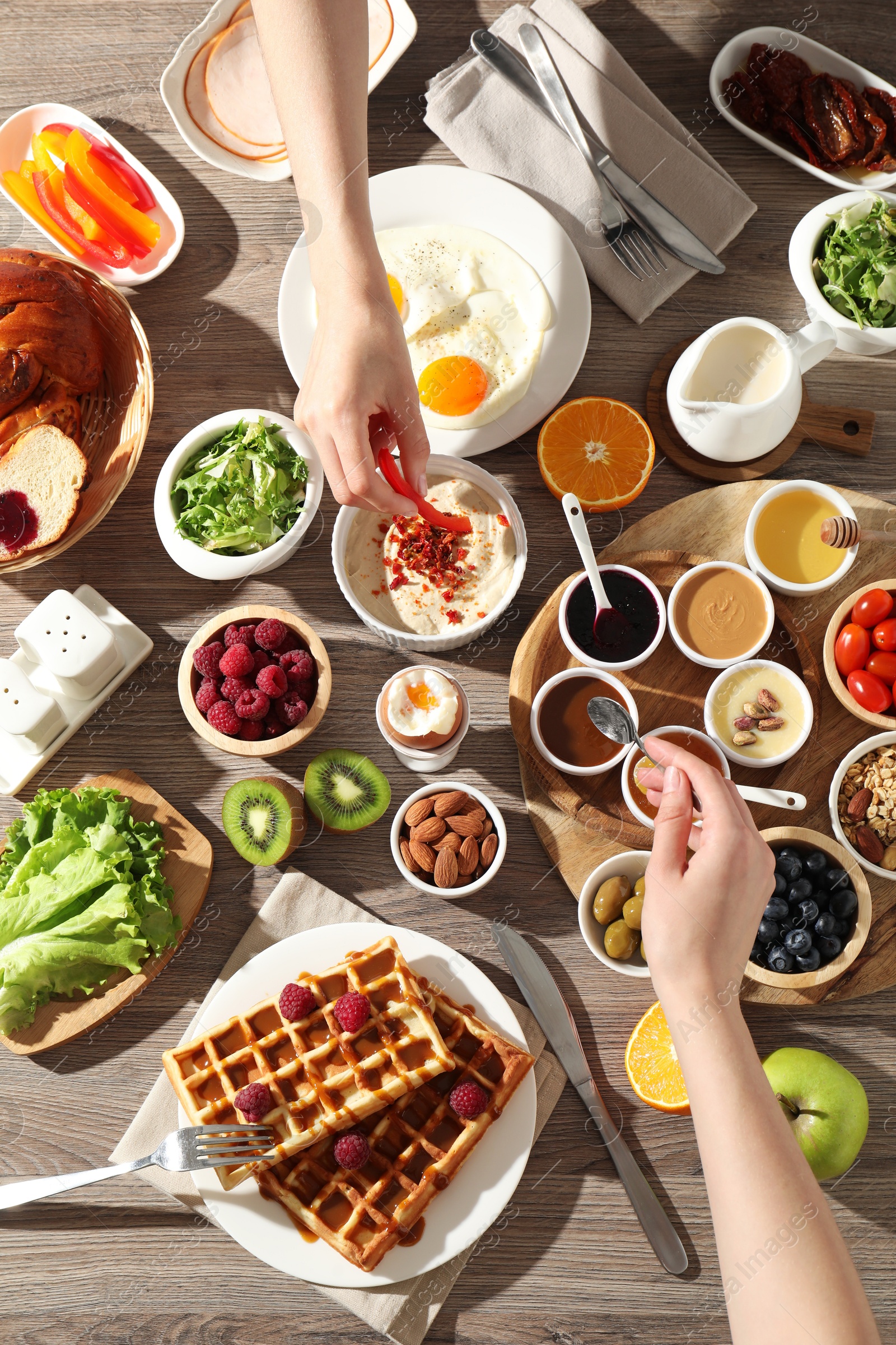 Photo of People having breakfast at wooden table, top view