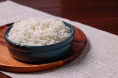 Photo of Delicious boiled rice served on table. Space for text