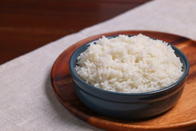 Photo of Delicious boiled rice in bowl on table