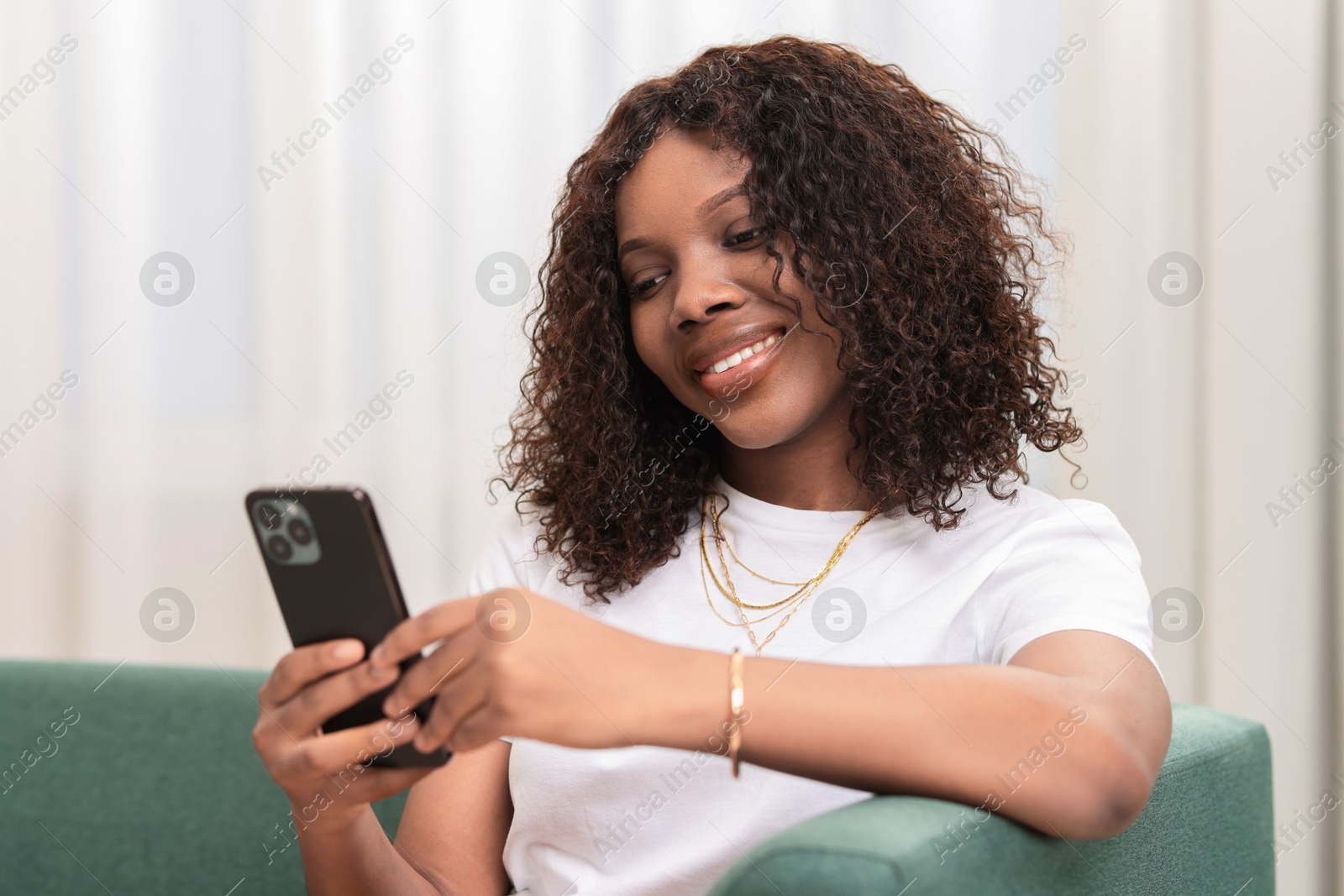 Photo of Beautiful woman using mobile phone at home