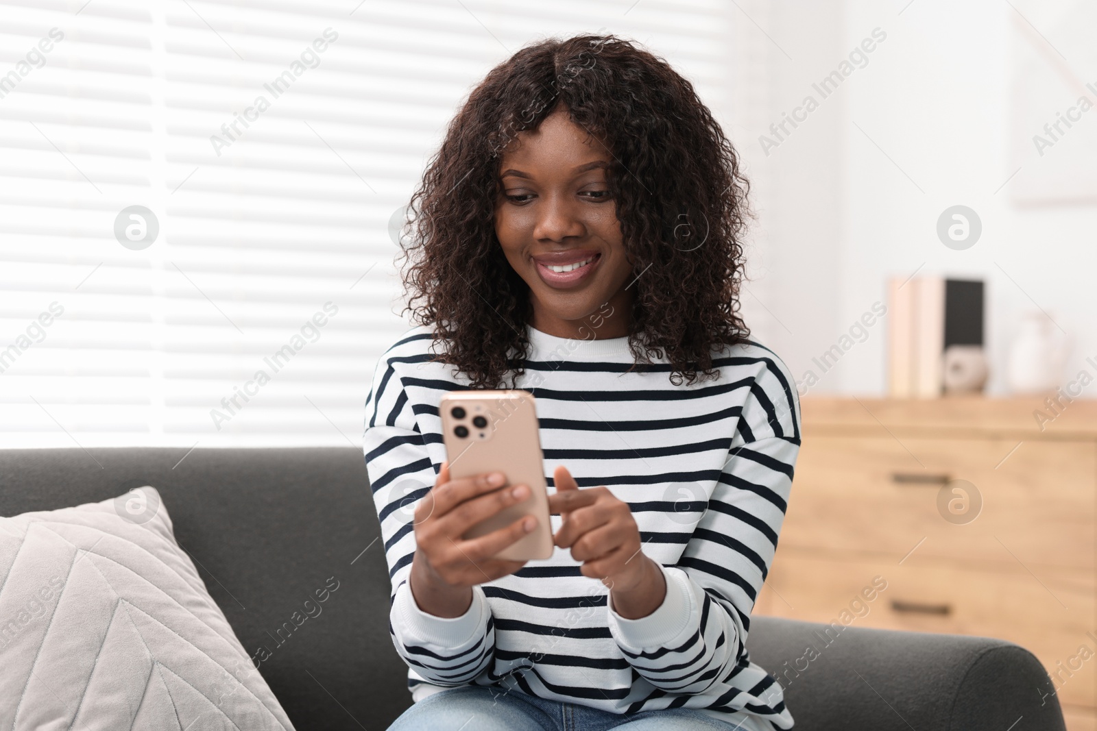 Photo of Beautiful woman using mobile phone at home