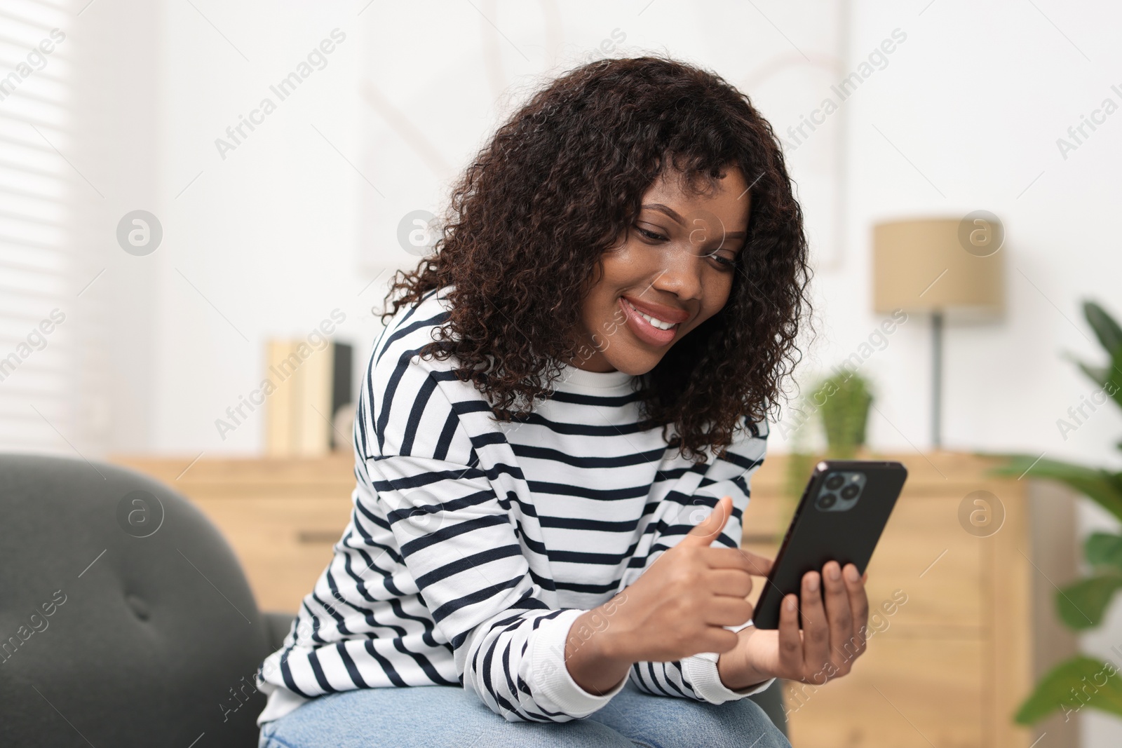 Photo of Beautiful woman using mobile phone at home