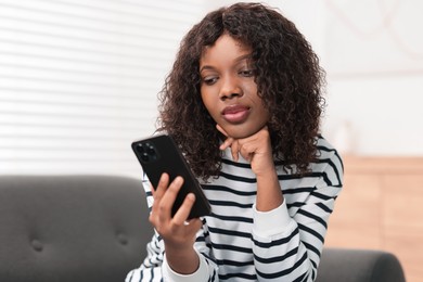 Photo of Beautiful woman using mobile phone at home