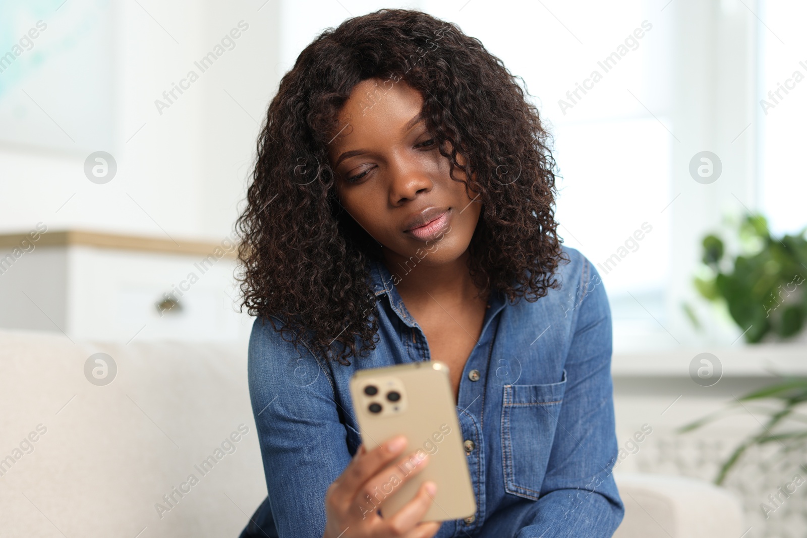 Photo of Beautiful woman using mobile phone at home