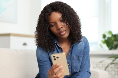 Photo of Beautiful woman using mobile phone at home