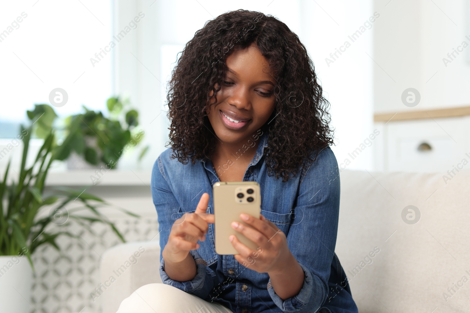 Photo of Beautiful woman using mobile phone at home