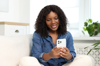 Photo of Beautiful woman using mobile phone at home