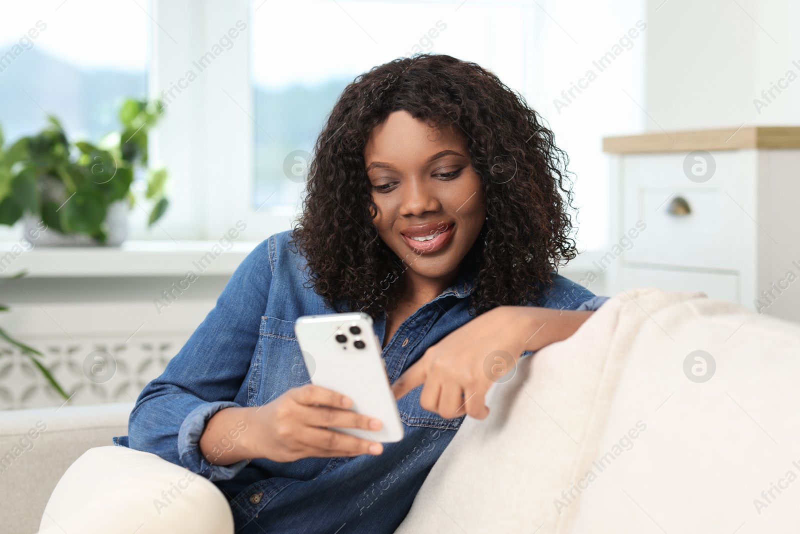 Photo of Beautiful woman using mobile phone at home