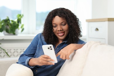 Photo of Beautiful woman using mobile phone at home