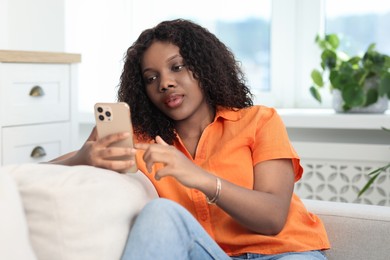 Photo of Beautiful woman using mobile phone at home