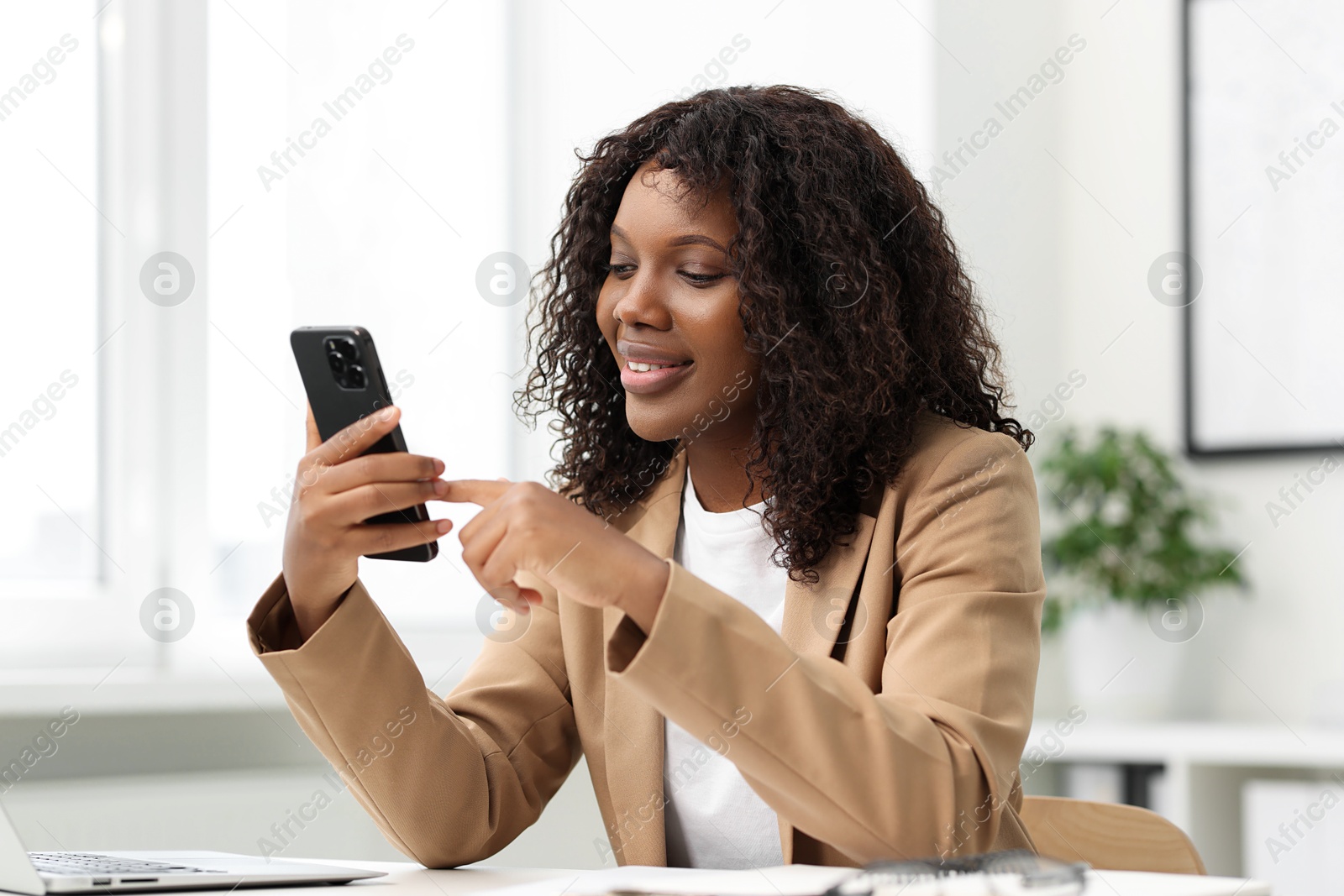 Photo of Beautiful woman using mobile phone in office