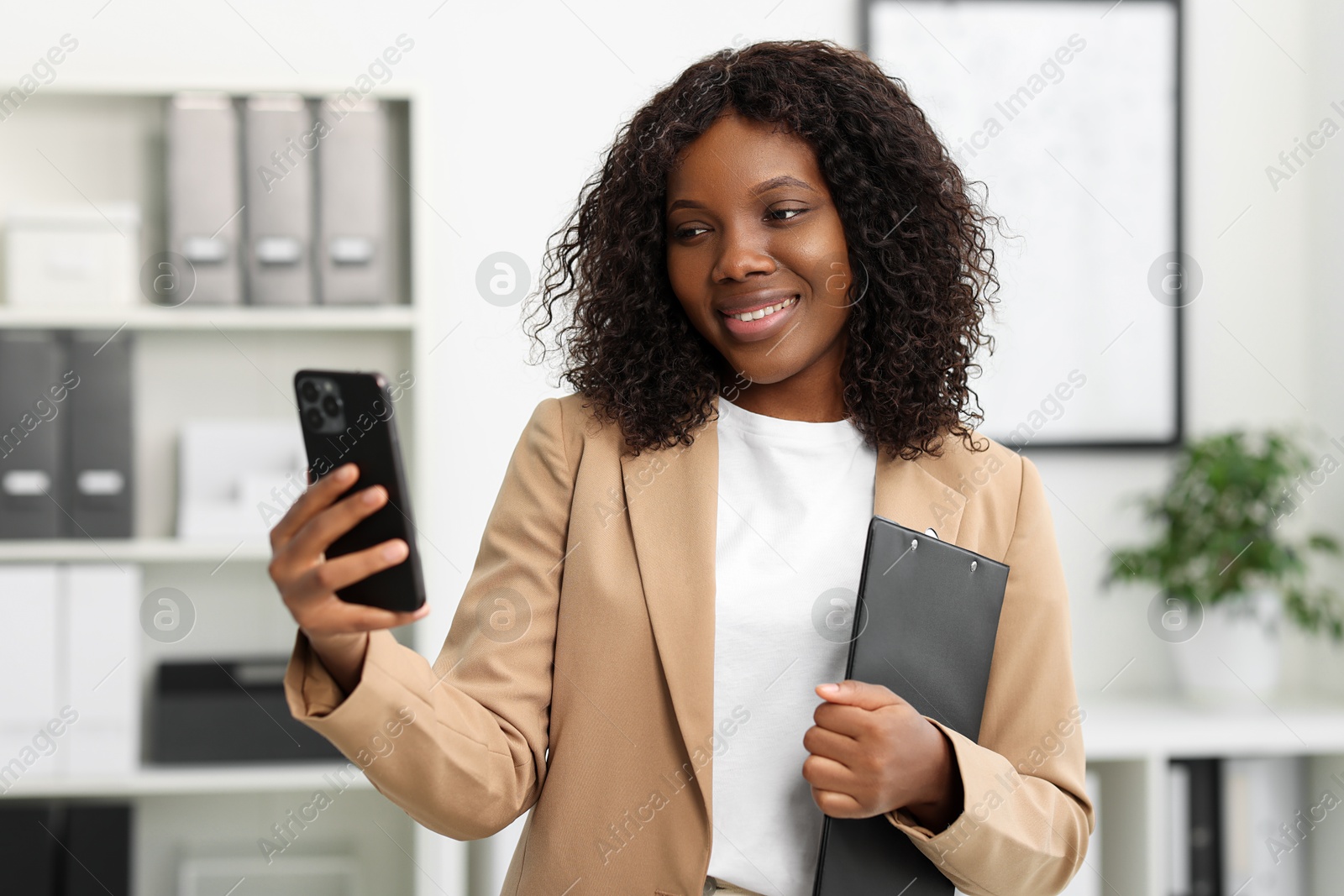 Photo of Beautiful woman using mobile phone in office