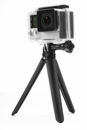 Modern action camera and tripod on white background