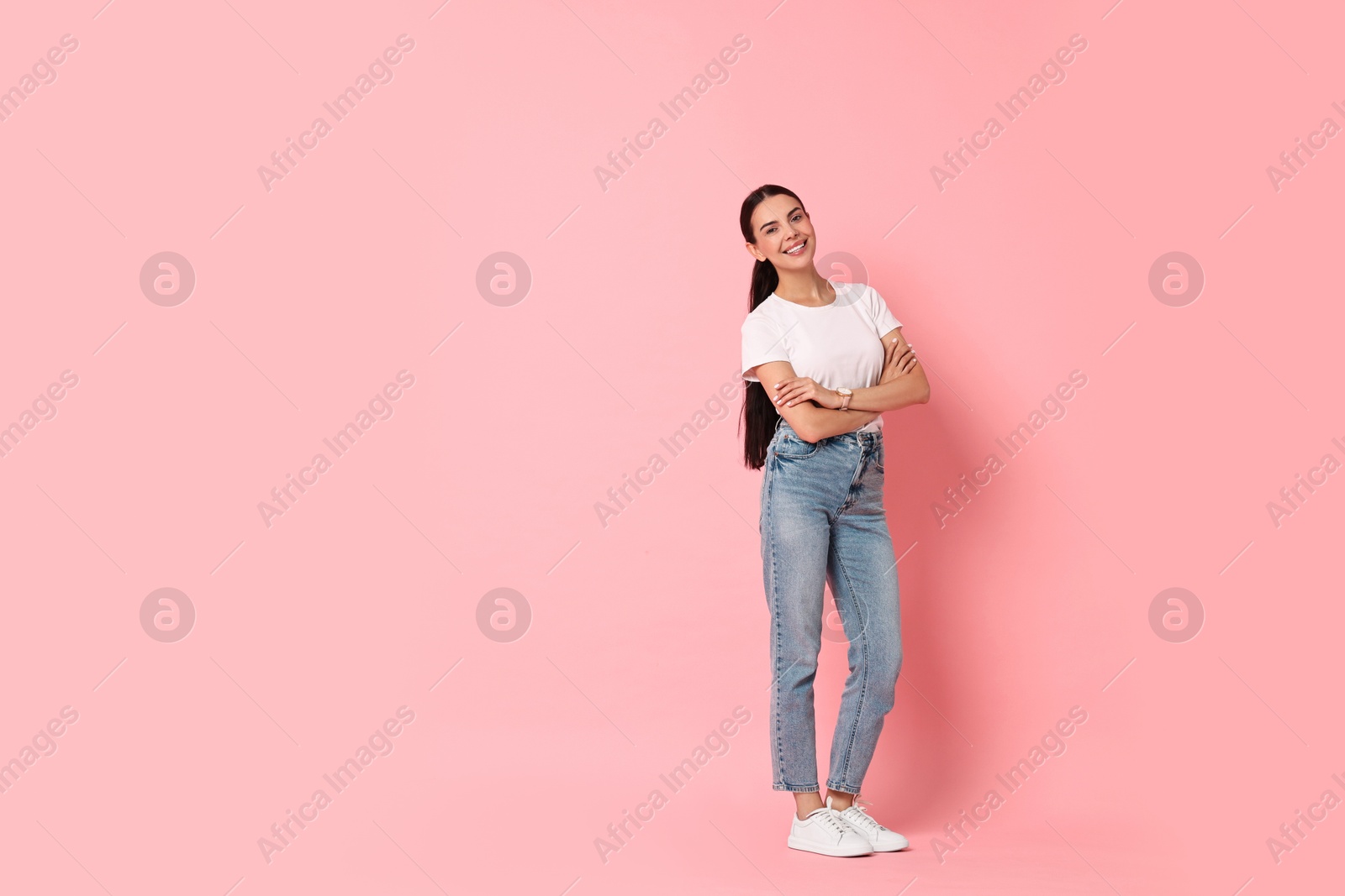 Photo of Smiling woman on pink background. Space for text