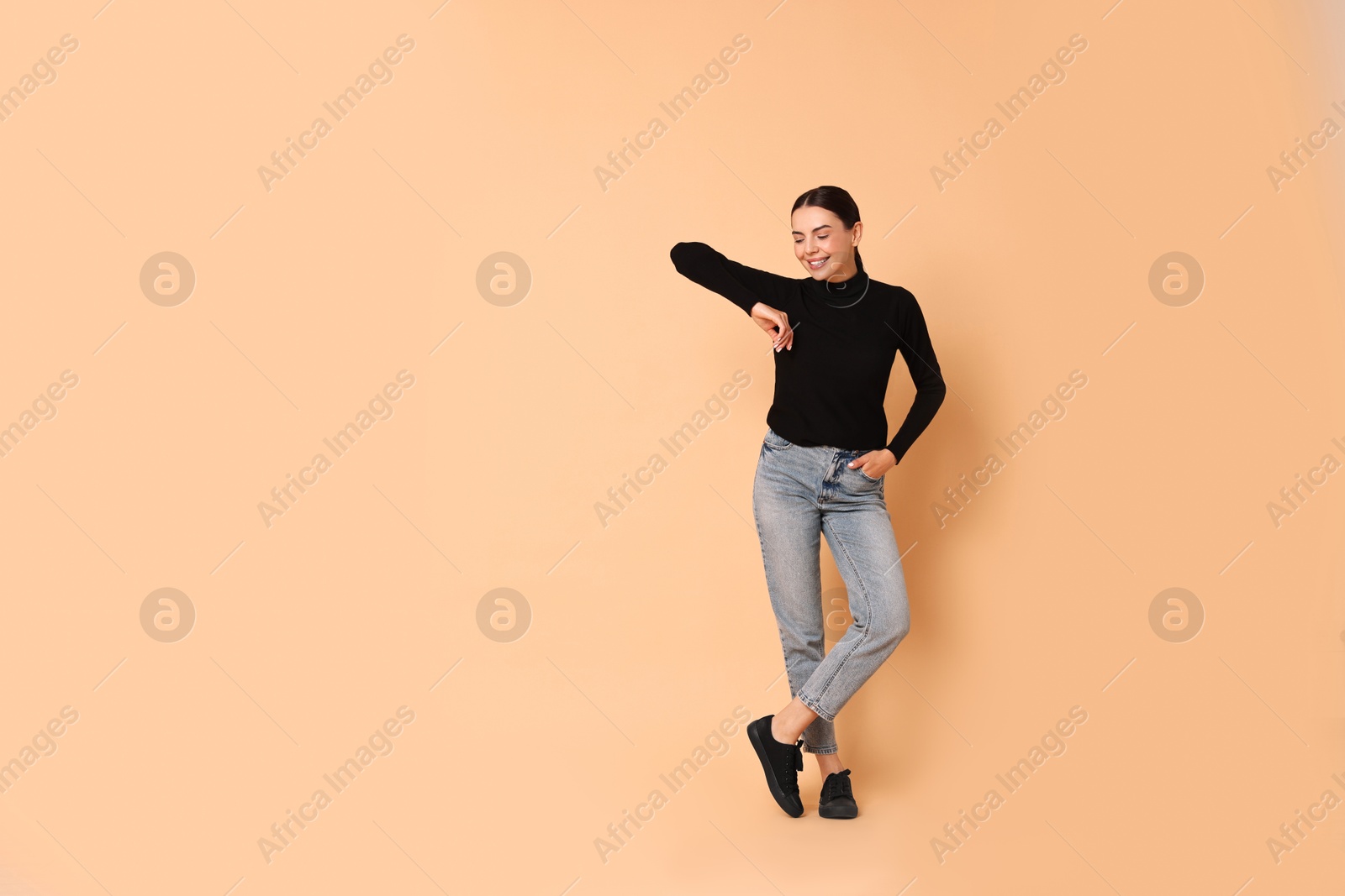 Photo of Smiling woman on beige background. Space for text