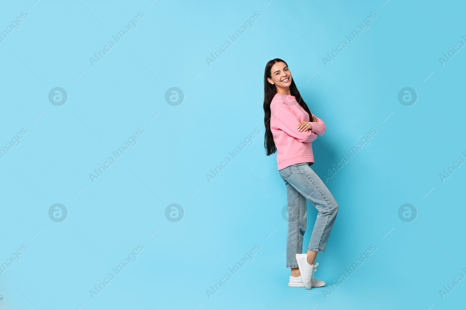 Photo of Smiling woman on light blue background. Space for text