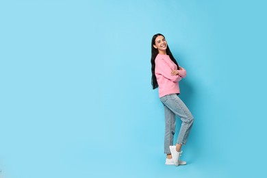 Photo of Smiling woman on light blue background. Space for text