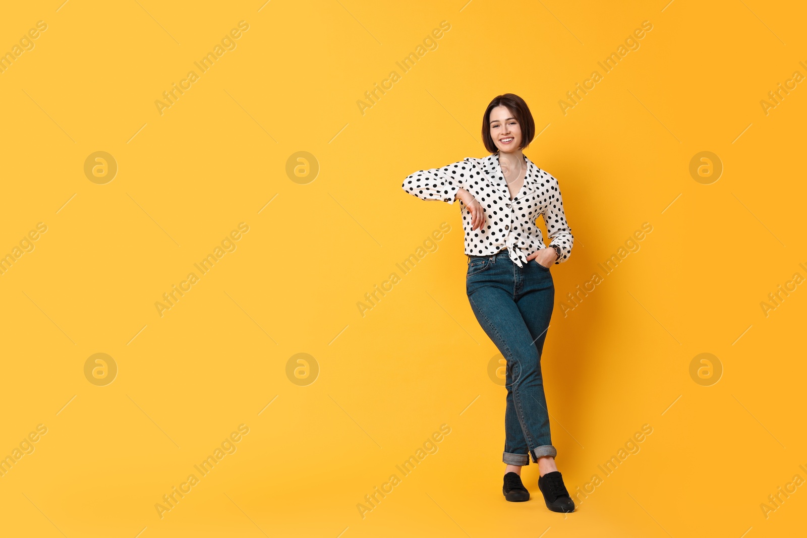 Photo of Smiling woman on yellow background. Space for text