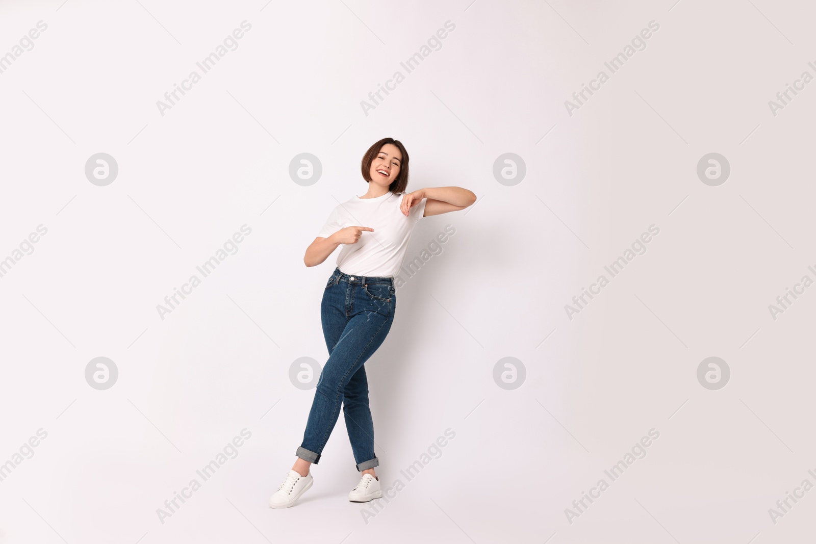 Photo of Happy woman pointing at something on white background