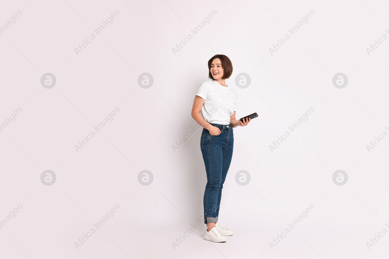 Photo of Happy woman with smartphone on white background. Space for text