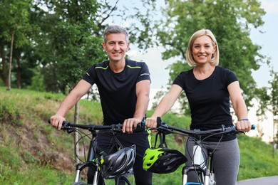 Happy couple riding bicycles in park. Healthy lifestyle