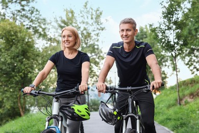 Happy couple riding bicycles in park. Healthy lifestyle