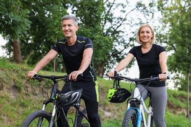 Happy couple riding bicycles in park. Healthy lifestyle