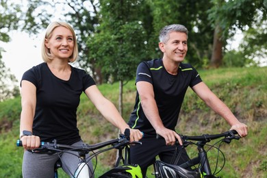 Photo of Happy couple riding bicycles in park. Healthy lifestyle