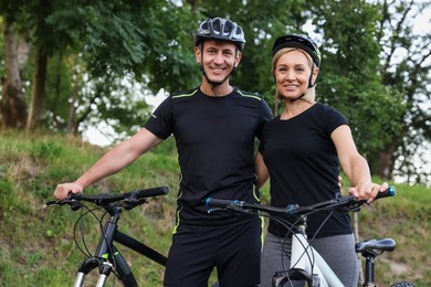 Photo of Happy couple with bicycles in park. Healthy lifestyle