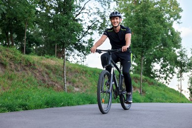 Photo of Happy man riding bicycle in park. Healthy lifestyle