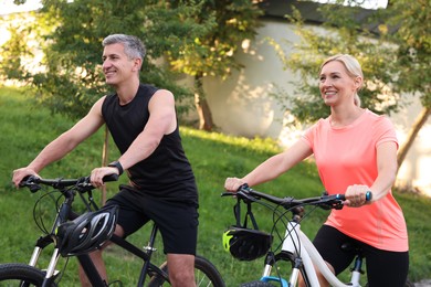 Happy couple riding bicycles in park. Healthy lifestyle