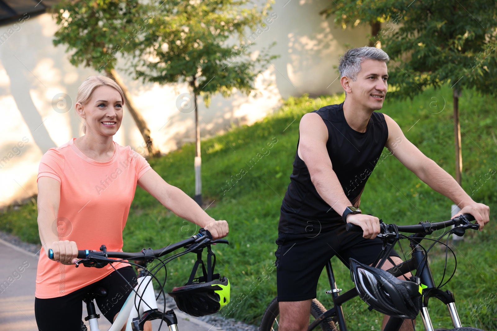 Photo of Happy couple riding bicycles in park. Healthy lifestyle